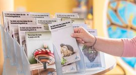 Person reaches for an information folder