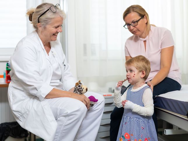 Ärztin mit Schmetterlingskind und Mutter im Behandlungsraum