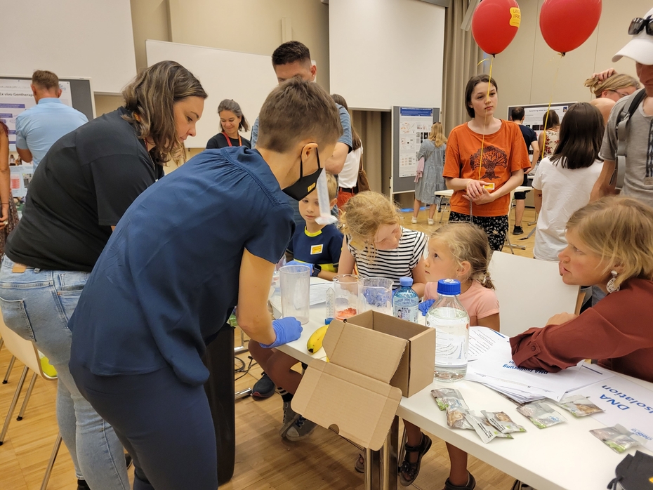 Zwei Frauen erklären Kindern die Forschung für die Schmetterlingskinder