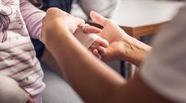 Doctor examines the hand of an EB patient