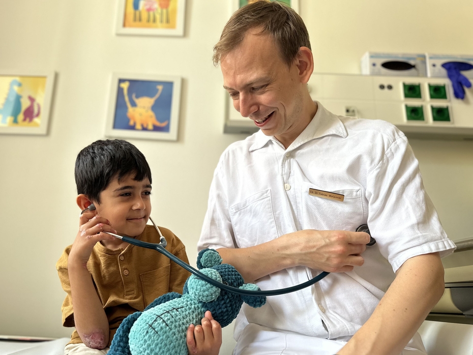 Schmetterlingskind mit einem Arzt Ein kleiner Patient untersucht einen Arzt