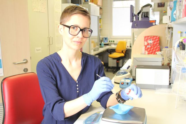 Junge Frau mit Brille bei der Arbeit mit einer Waage