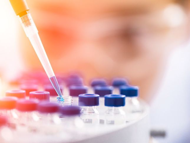 Scientist working in the laboratory with rainbow colored test tubes