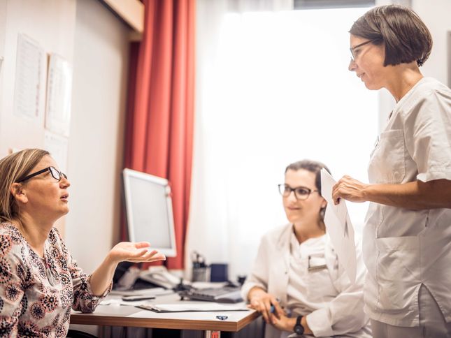 Patientin im Gespräch mit zwei Ärztinnen