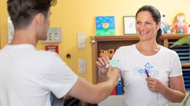 EB patient hands over his e-card to the receptionist of the EB House