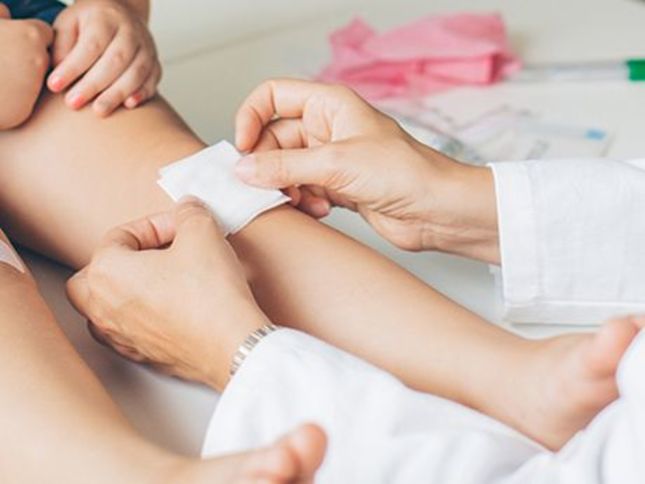 Doctor places a dressing on the knee of a child