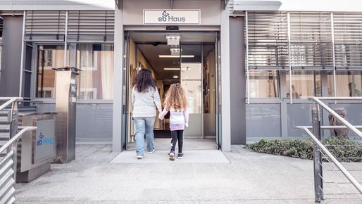 Zwei Personen betreten Hand in Hand das EB-Haus