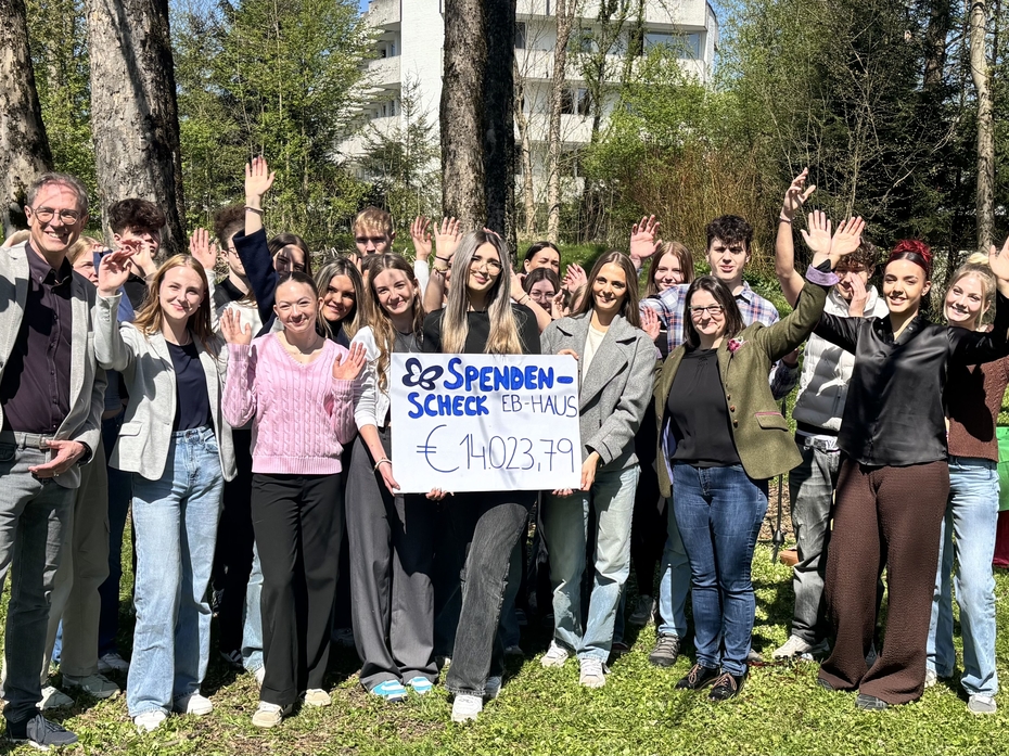 Gruppe von Schülerinnen und Schülern halten einen Spendenscheck